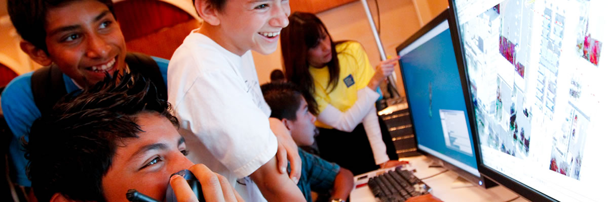 Excited students viewing results on computer monitor.